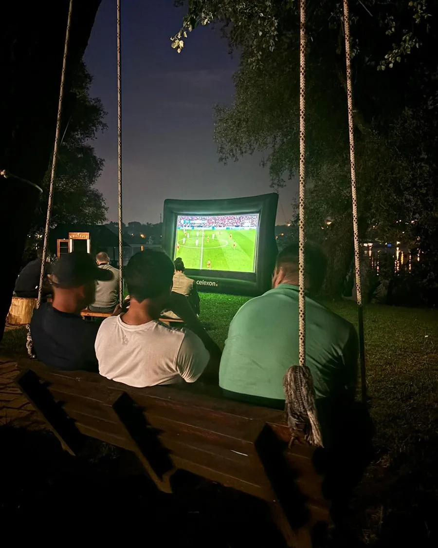 Gledanje utakmice na velikom platnu uveče kraj reke