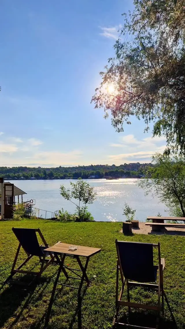 Ležaljke i stočić na travi sa pogledom na reku Savu