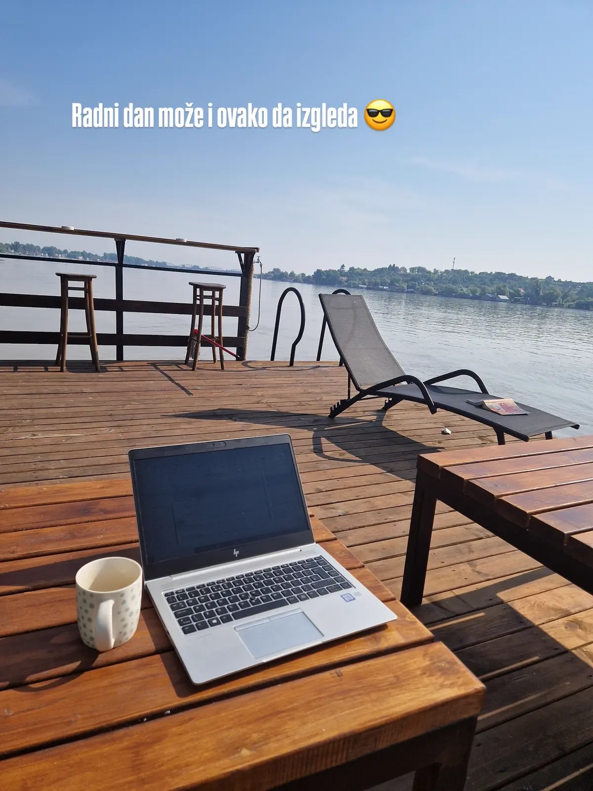 Drveni splav na reci Savi sa stolom i pogledom na drugu obalu